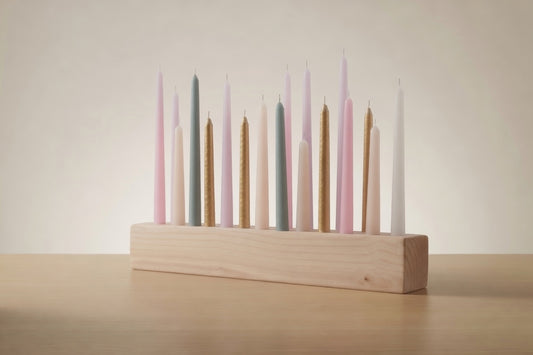 Set of colorful candles in a wooden holder on a neutral background